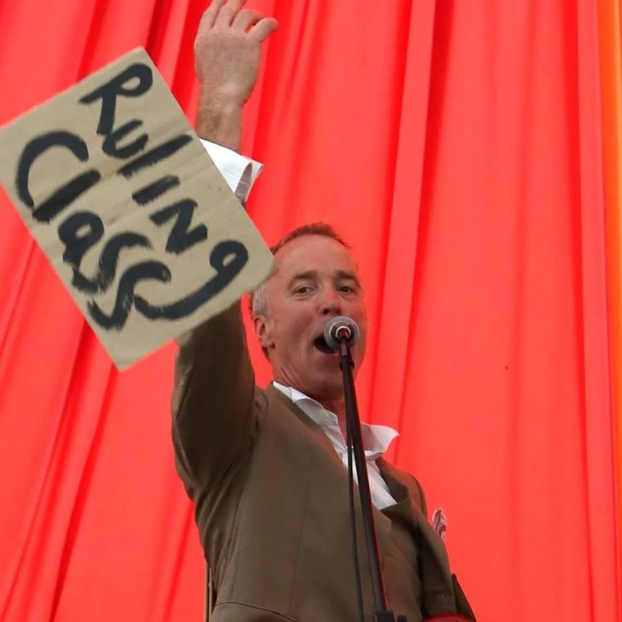 Live photo: John holding a cardboard sign reading ‘Wanted Men’